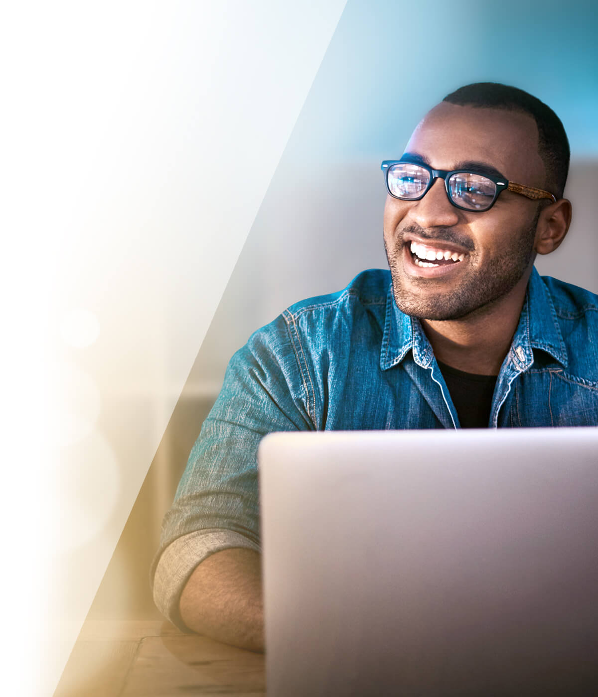 Smiling man looking up from his laptop