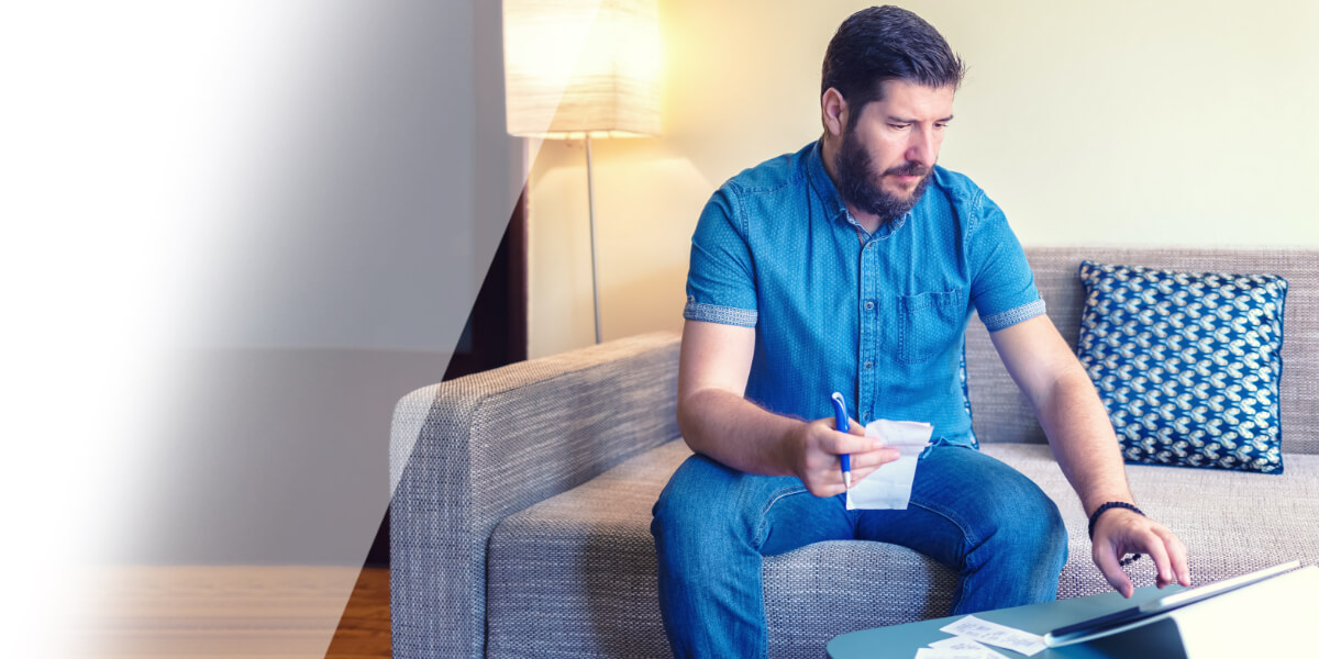 Man looking at slips and laptop