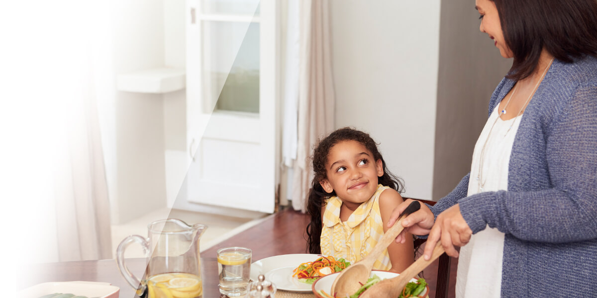 Mother dishing food for daughter