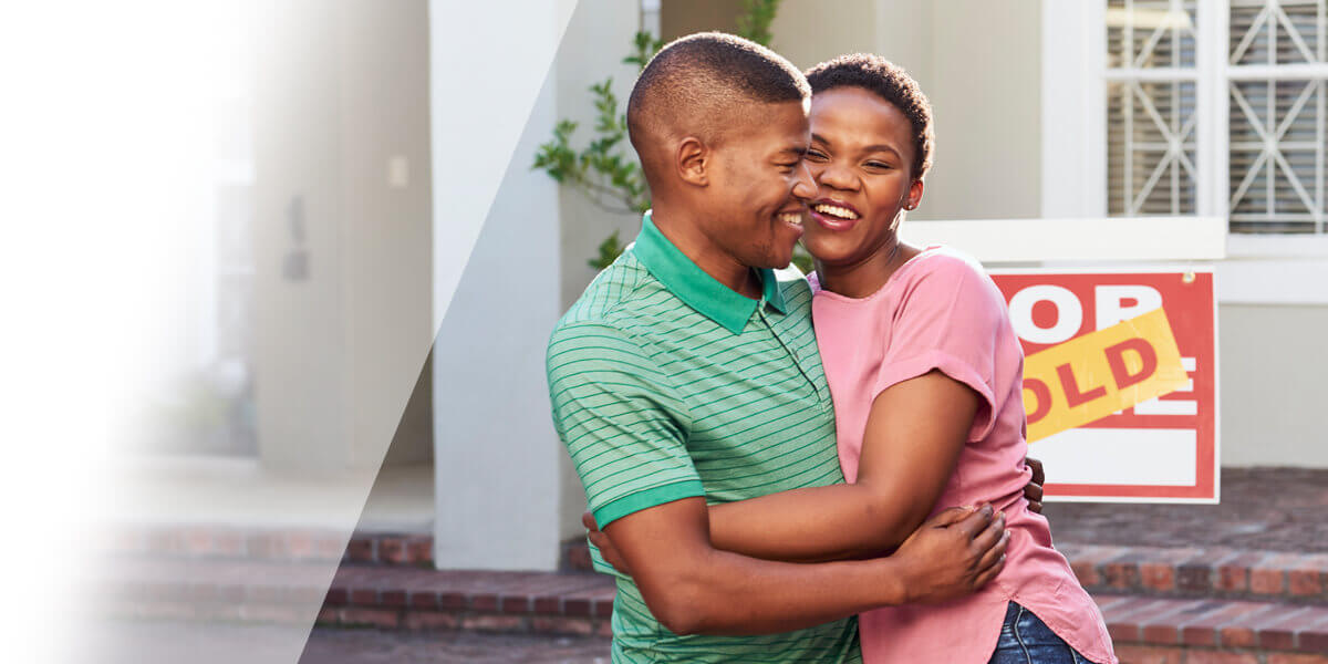 Couple standing in front of new home